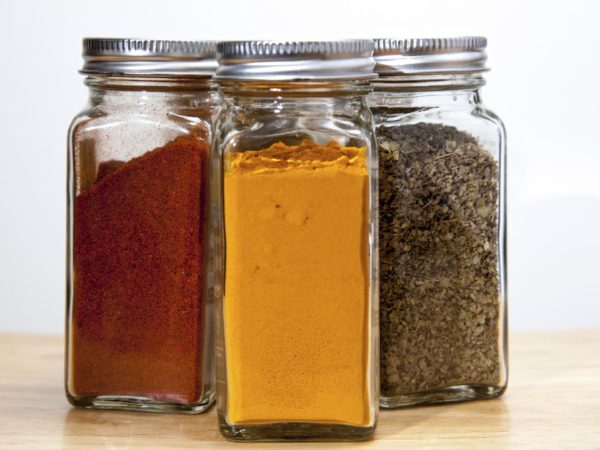 Cayenne pepper, turmeric & Coriander spices in square jars.