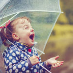 Little girl with umbrella in autumn