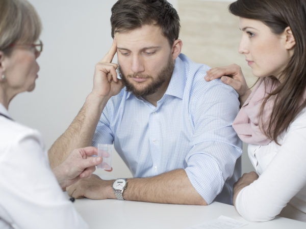Ill man and assisting wife ad doctor's office