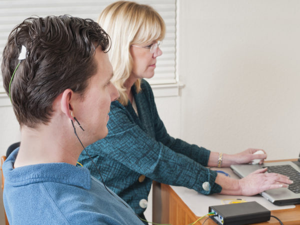 "Psychiatrist with her patient that has electrodes attached to his head, during a session of neurofeedback, which is a type of biofeedback. Shallow dof with focus on man.Click below for more from this series:"